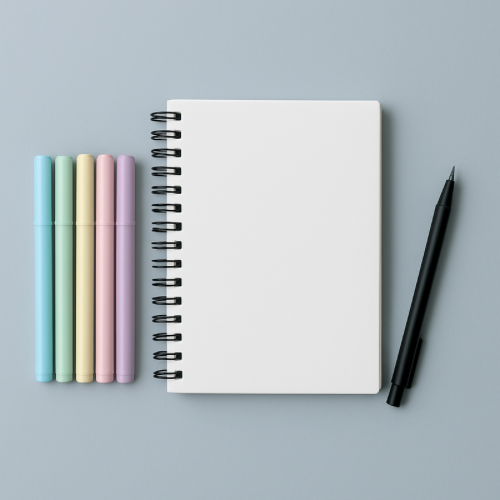 Light gray-blue flat-lay with sketchbook and pastel pens representing easy creative challenges for the new year. challenges after 50.
